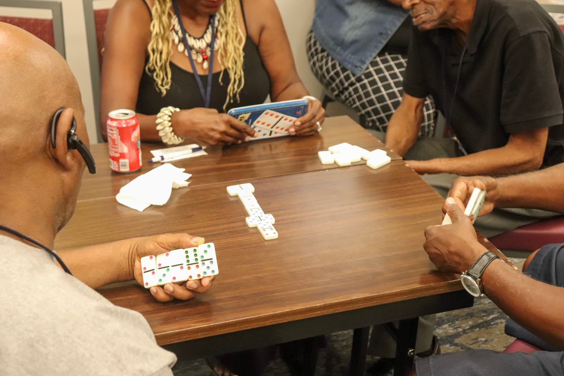 Cousins playing dominoes around the table